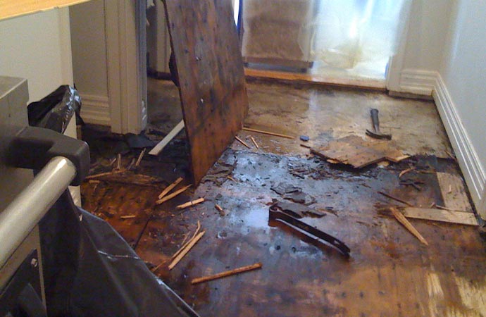 Water damage visible on home wooden floor.