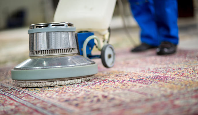 worker cleaning rug