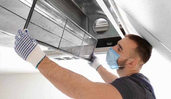 worker cleaning air duct