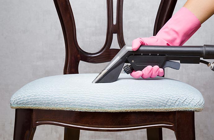Worker wearing protective glove cleaning a chair