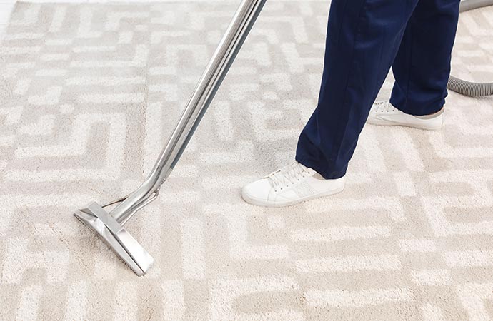 worker removing dirt from carpet with professional vacuum cleaner carpet cleaning process